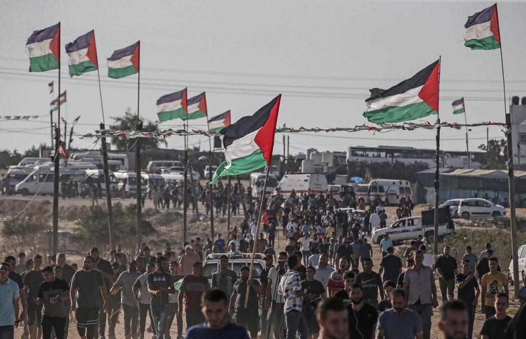 متظاهرون فلسطينيون قرب السياج الفاصل شرقي قطاع غزة. (محمود همص/أ ف ب)