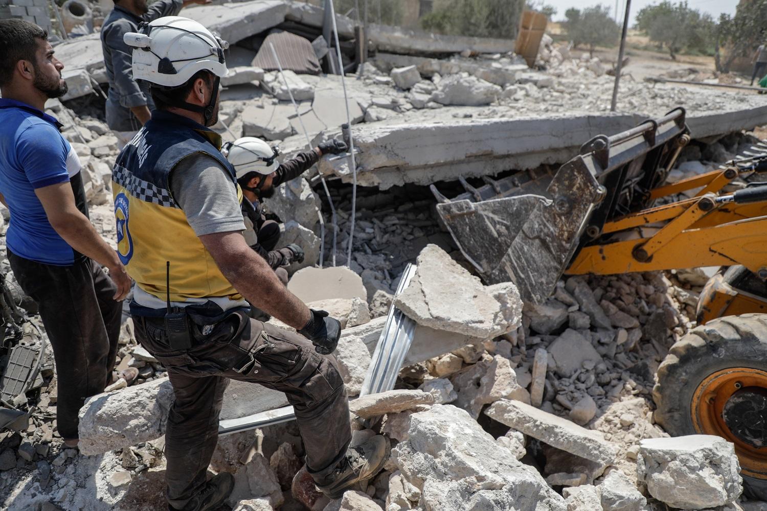 عناصر من الدفاع المدني السوري يبحثون عن ضحايا في موقع غارة جوية. 17 أغسطس / آب 2019. (أ ف ب)