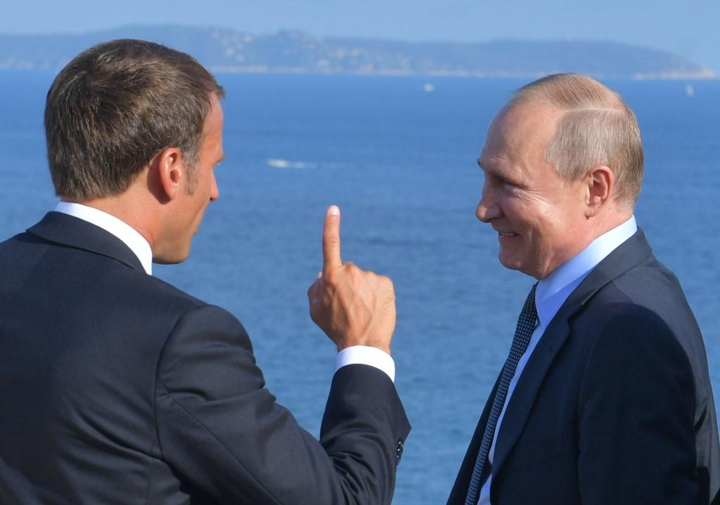الرئيس الروسي فلاديمير بوتين (يمين)، والرئيس الفرنسي إيمانويل ماكرون (يسار). (أ ف ب)