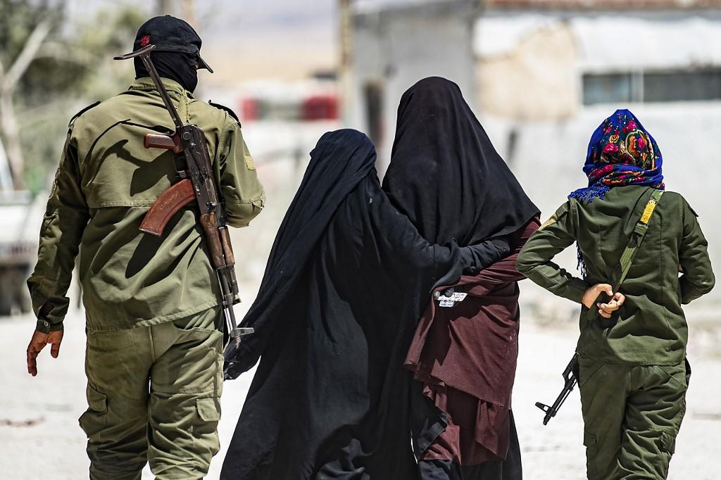 دورية أمنية داخلية ترافق نساء قيل إنهن زوجات مقاتلين في تنظيم (داعش) الإرهابي في معسكر الهول في محافظة الحسكة شمال شرق سوريا، 23 تموز/يوليو 2019. أ ف ب 