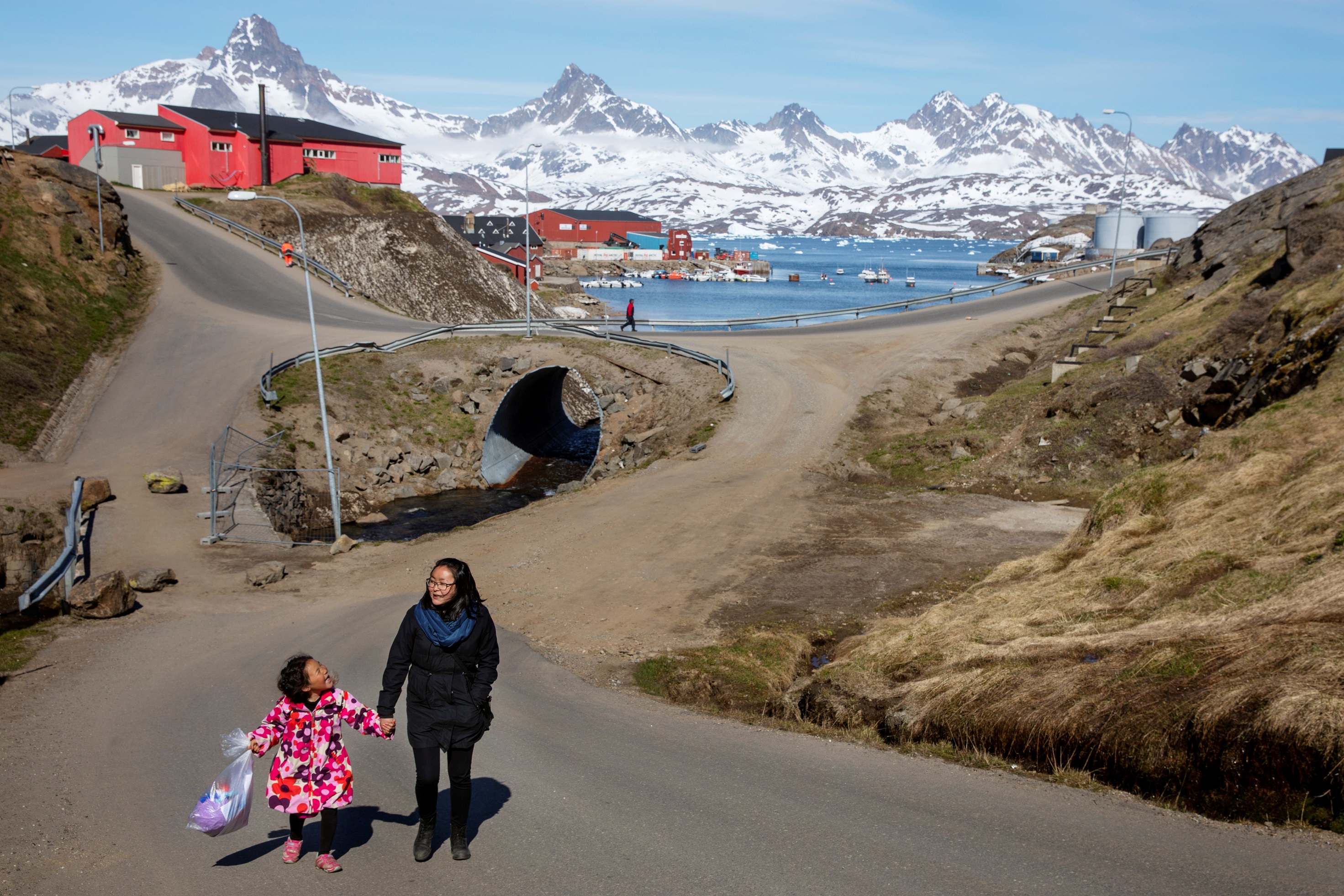 امرأة وطفلة تسيران في أحد شوارع جزيرة غرينلاند، 15 حزيران/يونيو. (لوكاس جاكسون/ رويترز)