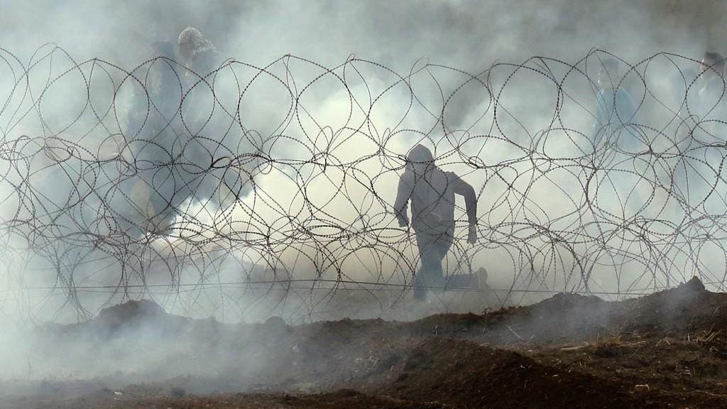متظاهر فلسطيني خلال إطلاق الجيش الإسرائيلي قنابل مسيلة للدموع. أ ف ب 