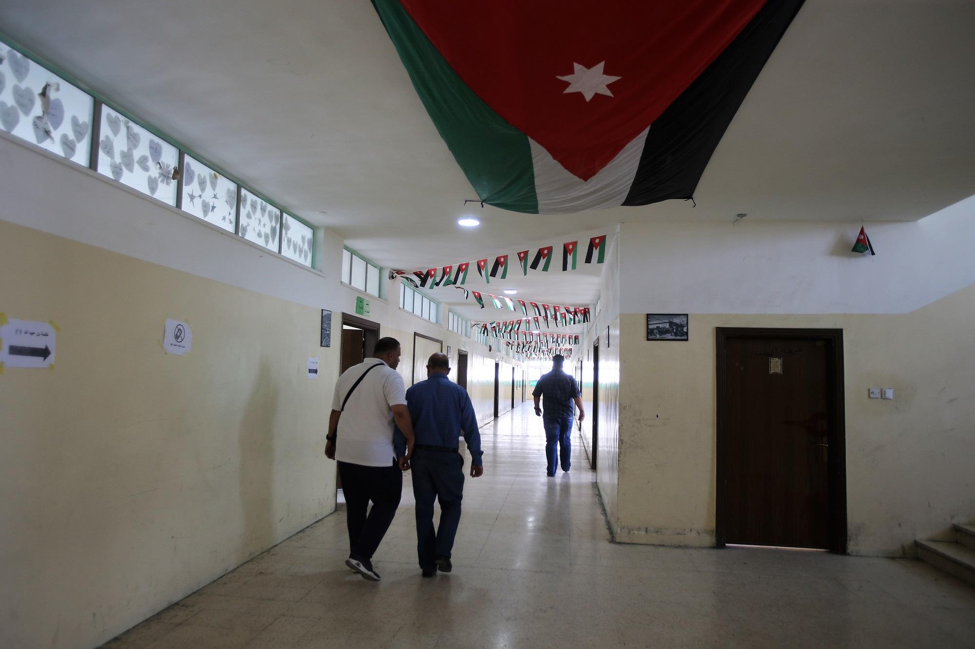 معلمون يسيرون في ممر بين غرف صفية في مدرسة حكومية خلال إضرابهم. (صلاح ملكاوي/ المملكة)