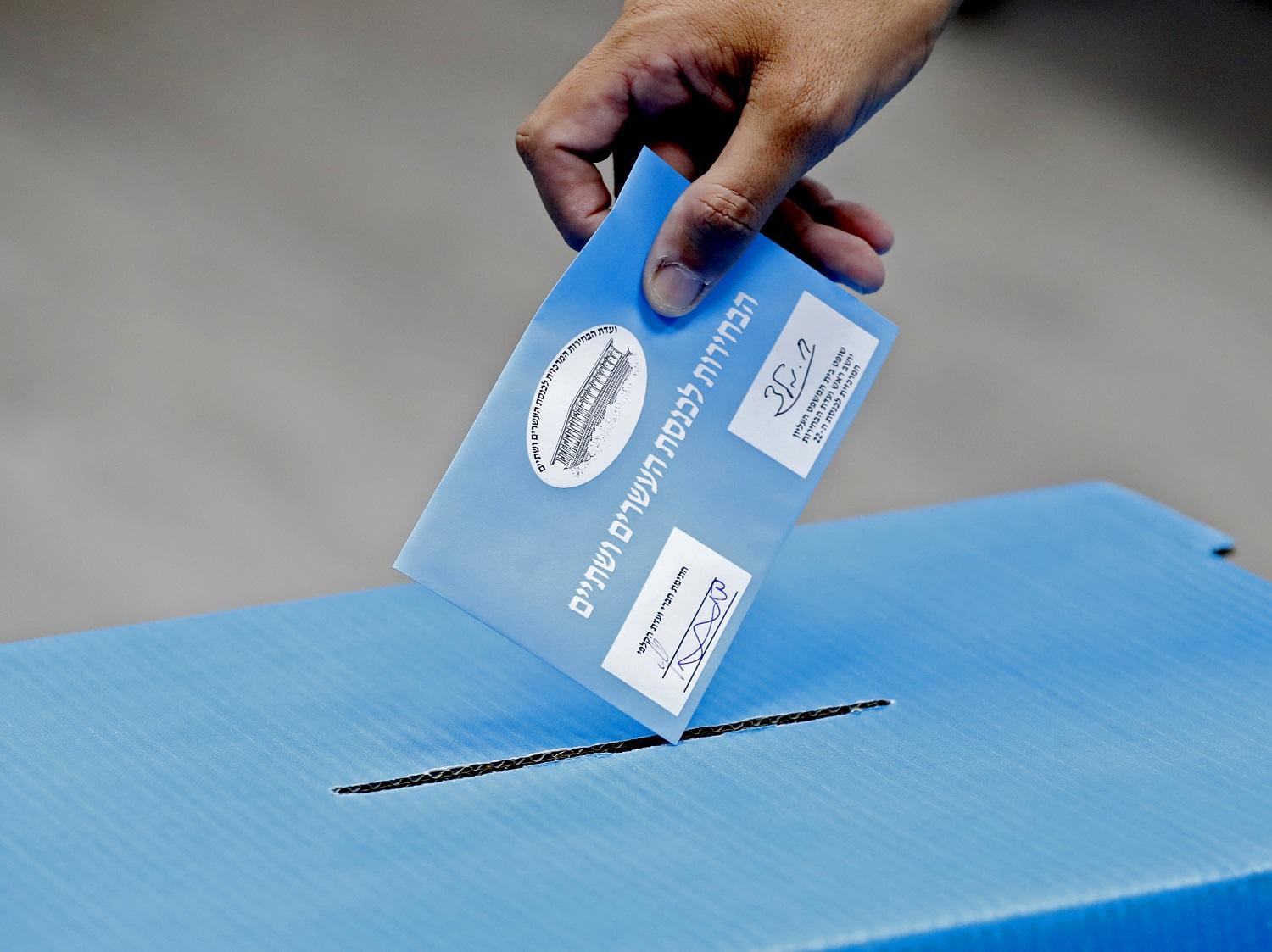 رجل يضع بطاقته الانتخابية في صندوق اقتراع خلال الانتخابات الإسرائيلية. مركز اقتراع في روش هاعين. 17 سبتمبر 2019. (أ ف ب)