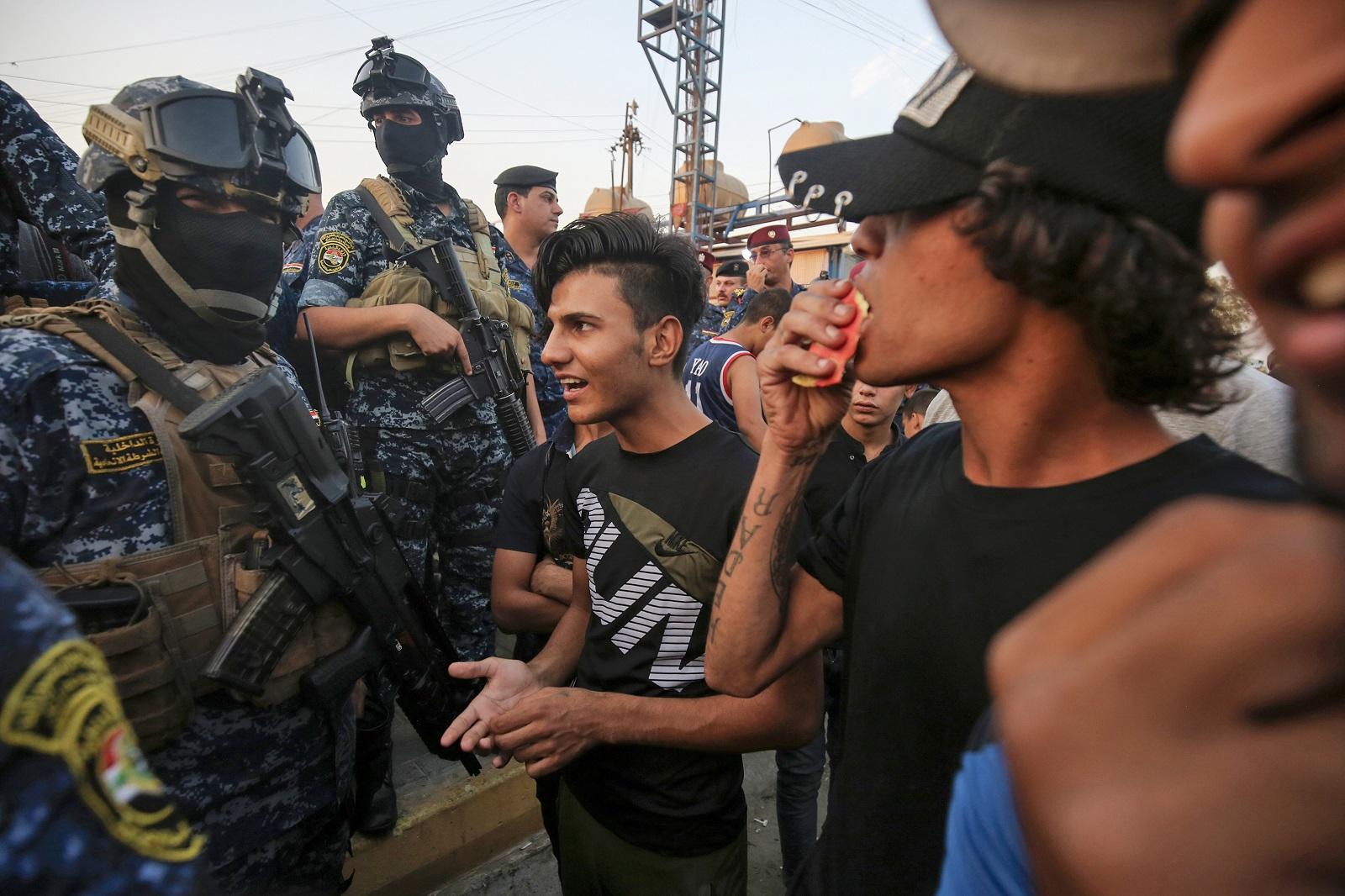 متظاهرون عراقيون يتحدثون مع أفراد من الشرطة في بغداد. 7 أكتوبر/تشرين الأول 2019. (أ ف ب)