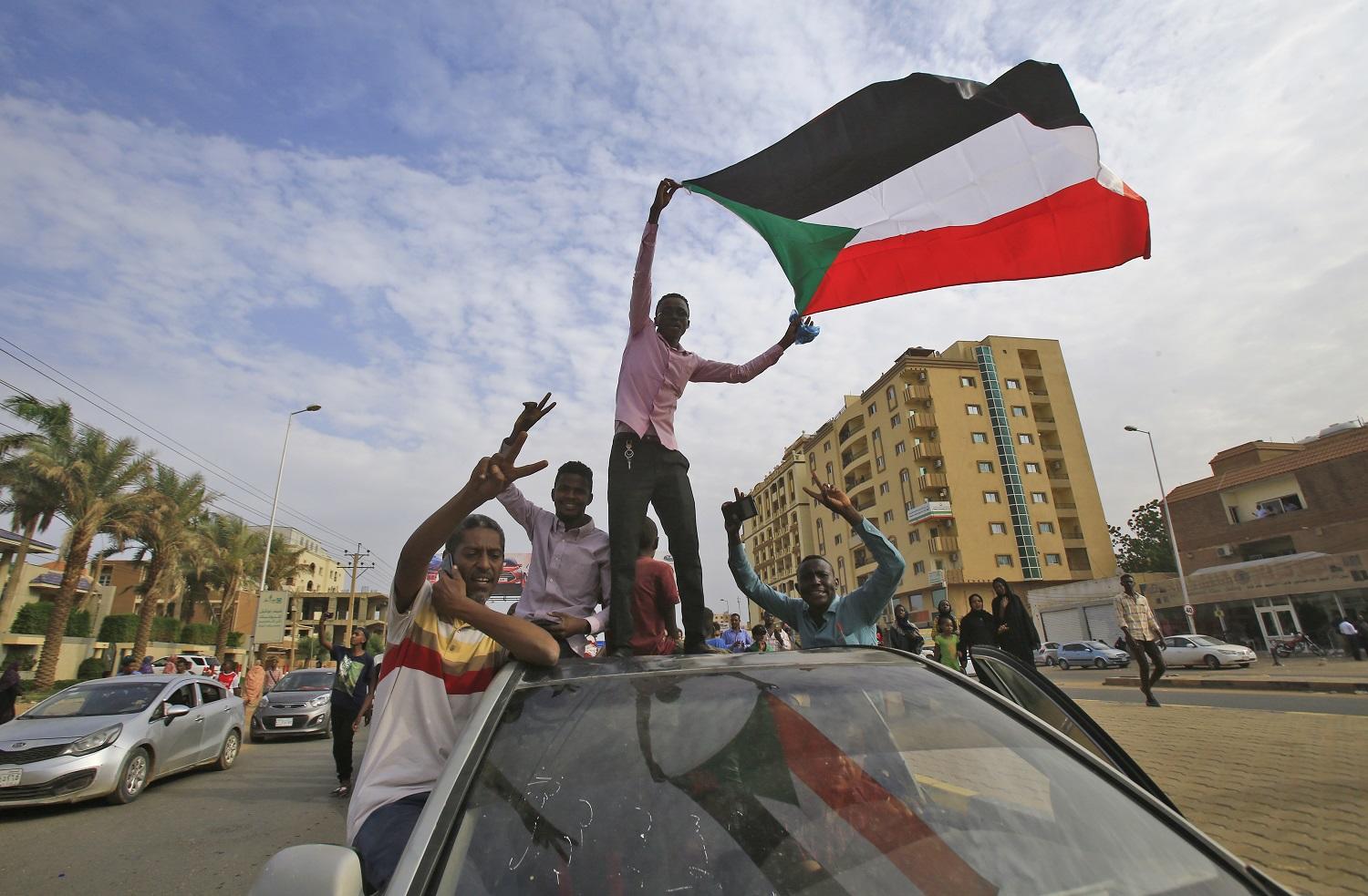 صورة أرشيفية لسوداني يرفع علم بلاده. أ ف ب 