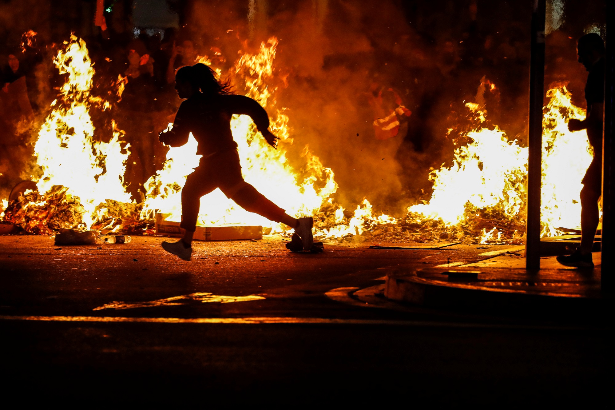 متظاهر يركض أثناء احتجاج بعد صدور حكم بشأن استفتاء على الاستقلال في برشلونة الإسبانية. 17 أكتوبر 2019. جون نازكا/ رويترز
