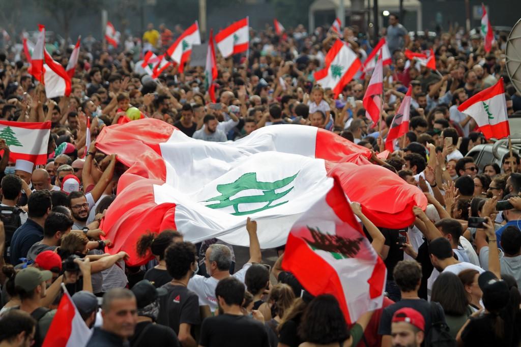 متظاهرون يلوحون بالأعلام الوطنية في العاصمة اللبنانية بيروت، 18 تشرين الأول/أكتوبر. (إبراهيم عمرو/ أ ف ب)