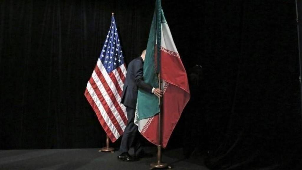 صورة أرشيفية لموظف يزيل العلم الإيراني بعد محادثات في مركز فيينا الدولي، 14 يوليو 2015. أ ف ب