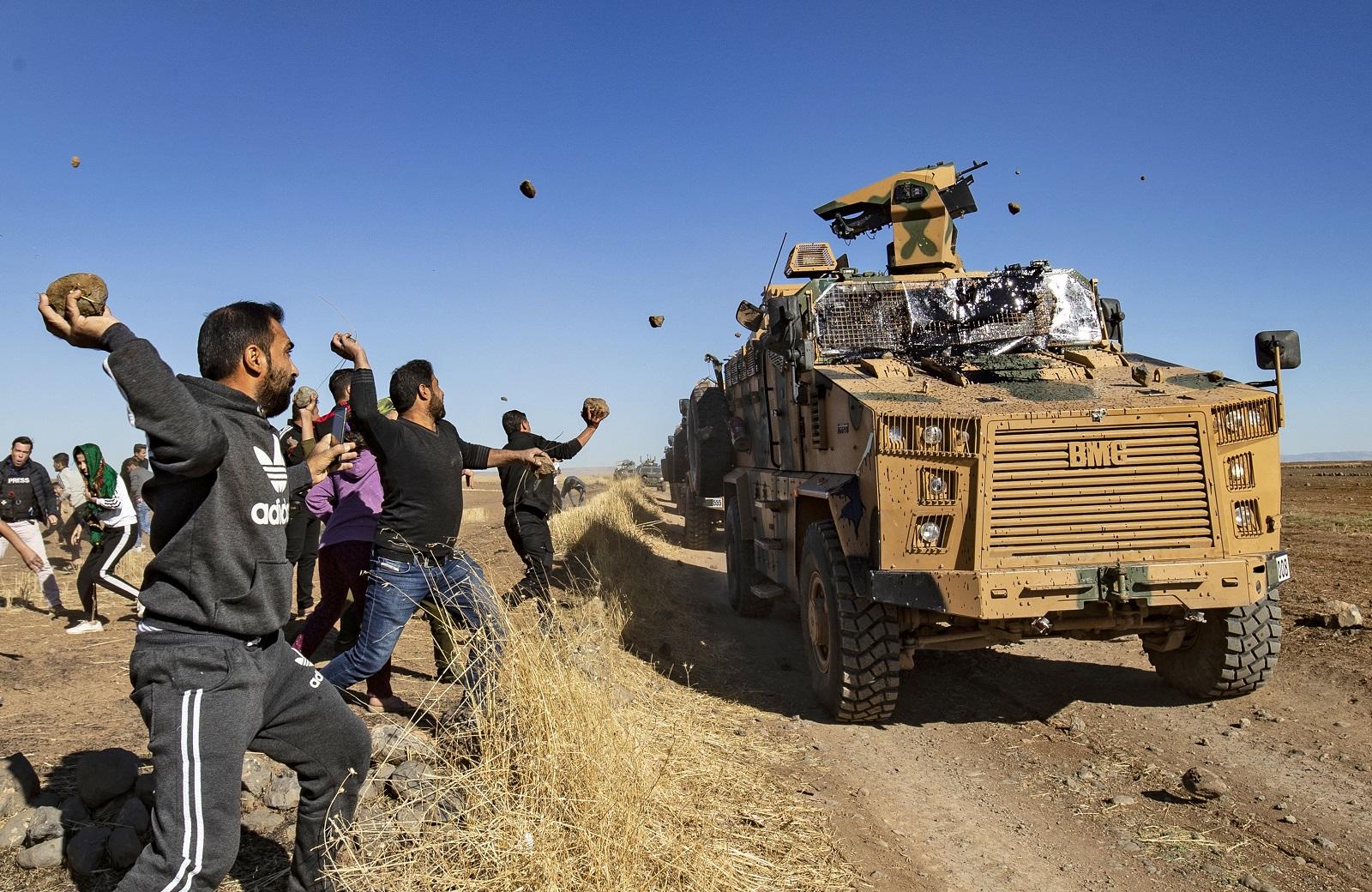 أكراد يرشقون حجارة على مركبة عسكرية أثناء دورية تركية روسية مشتركة في الجزء الشمالي الشرقي من الحسكة. 8 نوفمبر 2019. (أ ف ب)