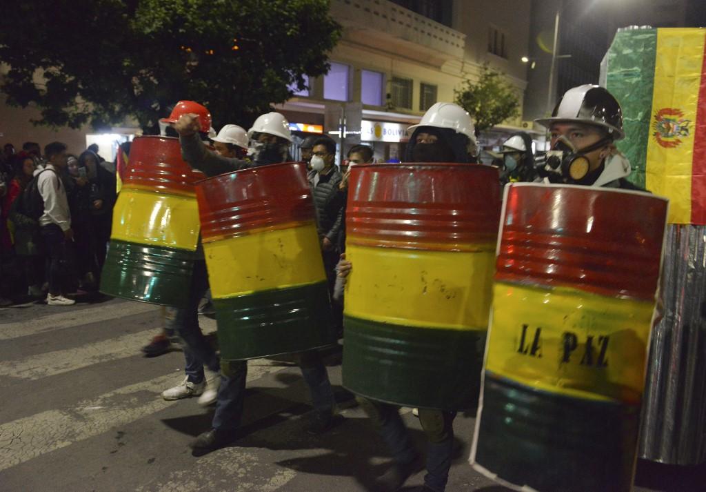 معارضون يحملون دروعًا أثناء احتجاج ضد الرئيس البوليفي إيفو موراليس في لاباز. (أ ف ب)