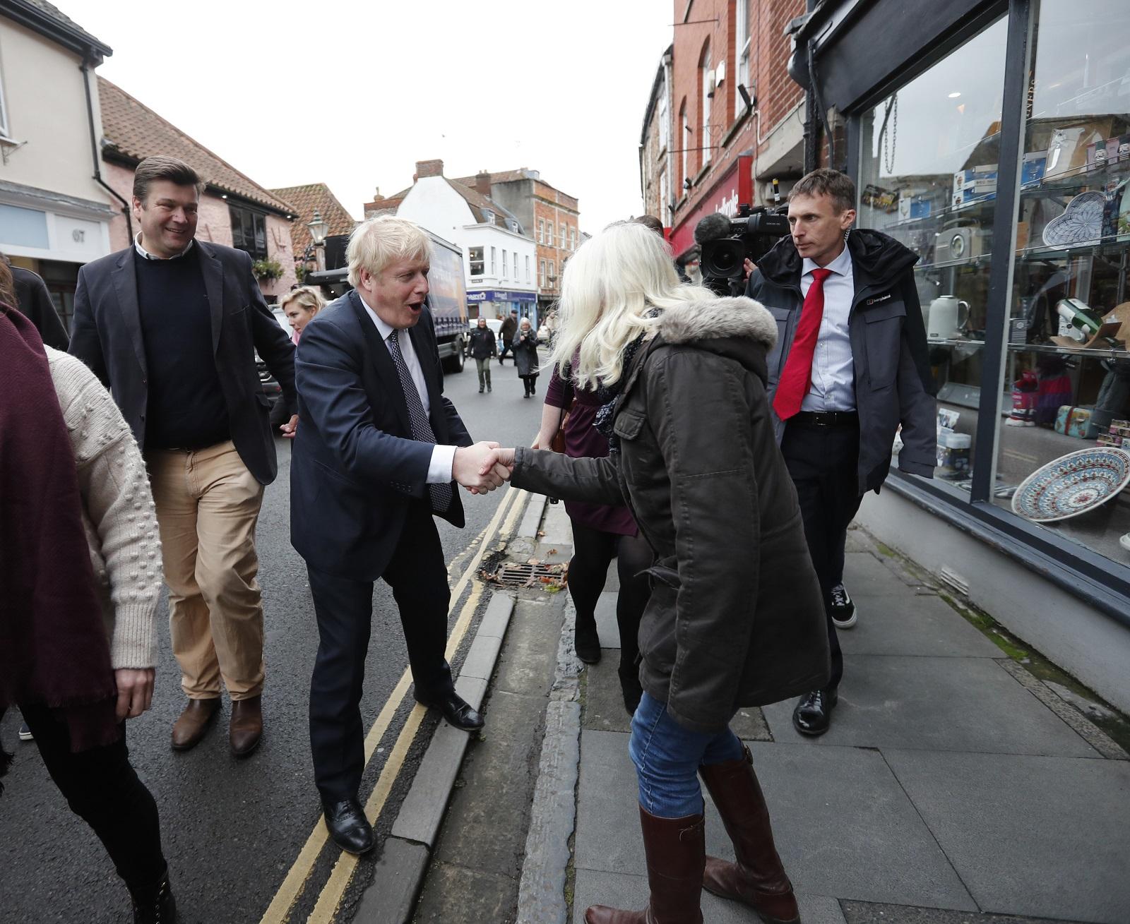 رئيس الوزراء البريطاني بوريس جونسون يصافح فتاة أثناء توقف حملة الانتخابات العامة جنوب غرب إنجلترا. 14 نوفمبر 2019. (أ ف ب)