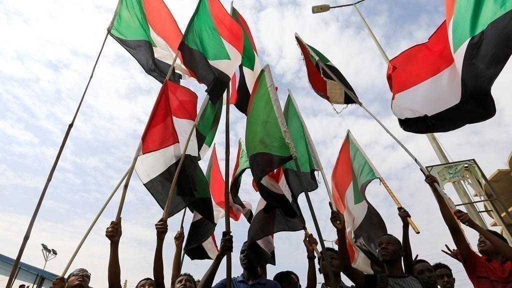 سودانيون يرفعون علم بلادهم. 1 أغسطس 2019. (رويترز)