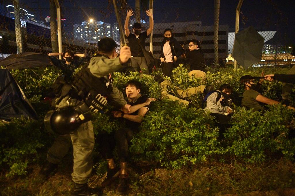 تحتجز الشرطة المتظاهرين والطلاب بعد أن حاولوا الفرار خارج حرم جامعة هونغ كونغ للفنون التطبيقية في حي هونغ هوم في هونغ كونغ في 19 نوفمبر 2019. نيكولاس عصفوري / أ ف ب 