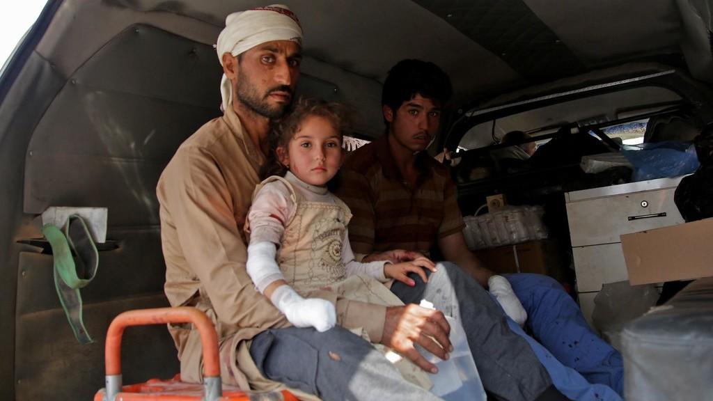 عائلة سورية في سيارة إسعاف شمال شرق سوريا، على الحدود مع تركيا. (أ ف ب)