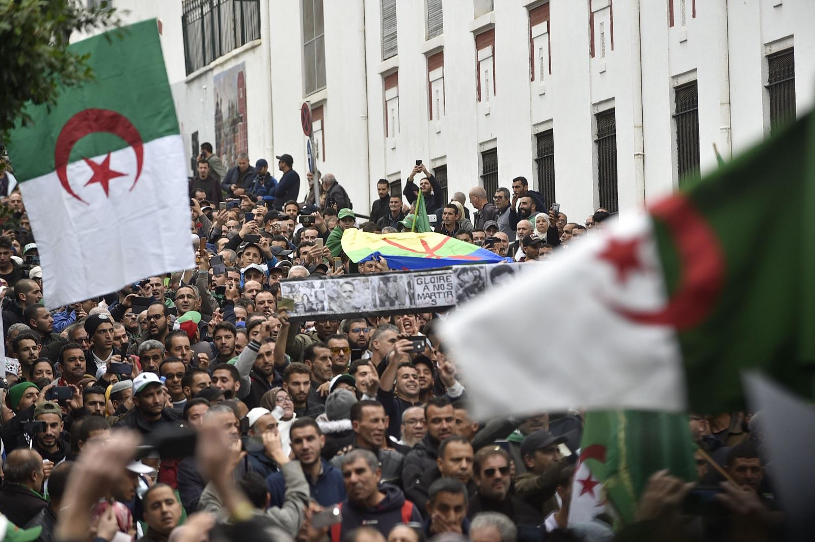 متظاهرون جزائريون يلوحون بالعلم الوطني خلال مظاهرة مناهضة للحكومة في وسط العاصمة الجزائر. 22 نوفمبر 2019. (أ ف ب)