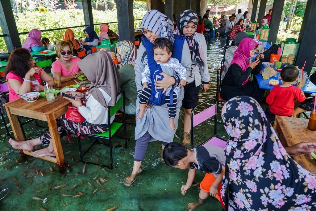 خدمة "عناية بالأقدام باستخدام السمك" في مطعم في مدينة يوغياكارتا في جزيرة جاوا الإندونيسية، 15 تشرين الثاني/نوفمبر 2019. (أ ف ب)