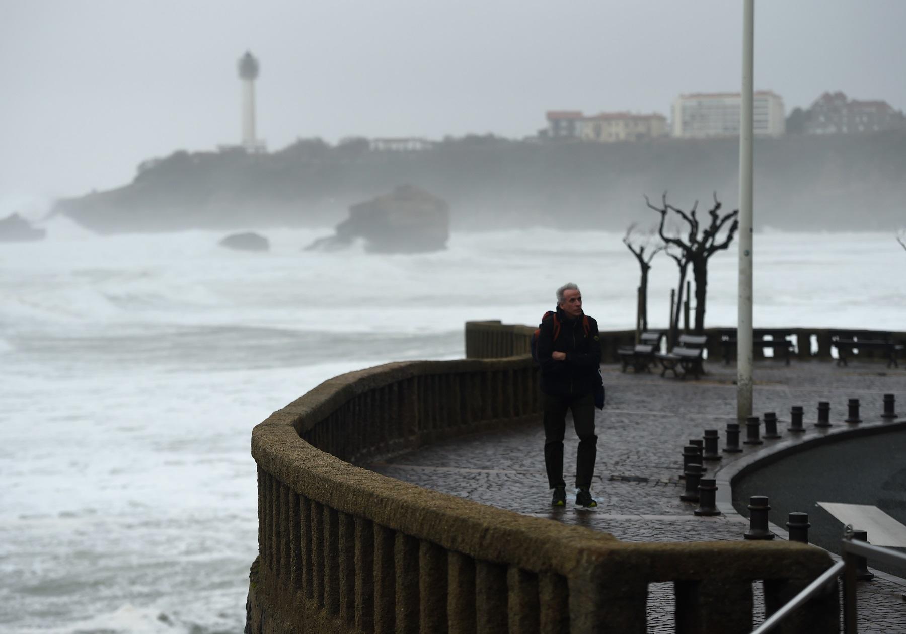 رجل يمشي أثناء العاصفة بالقرب من غراند بلاج جنوب غرب فرنسا. 13 ديسمبر 2019. (أ ف ب)