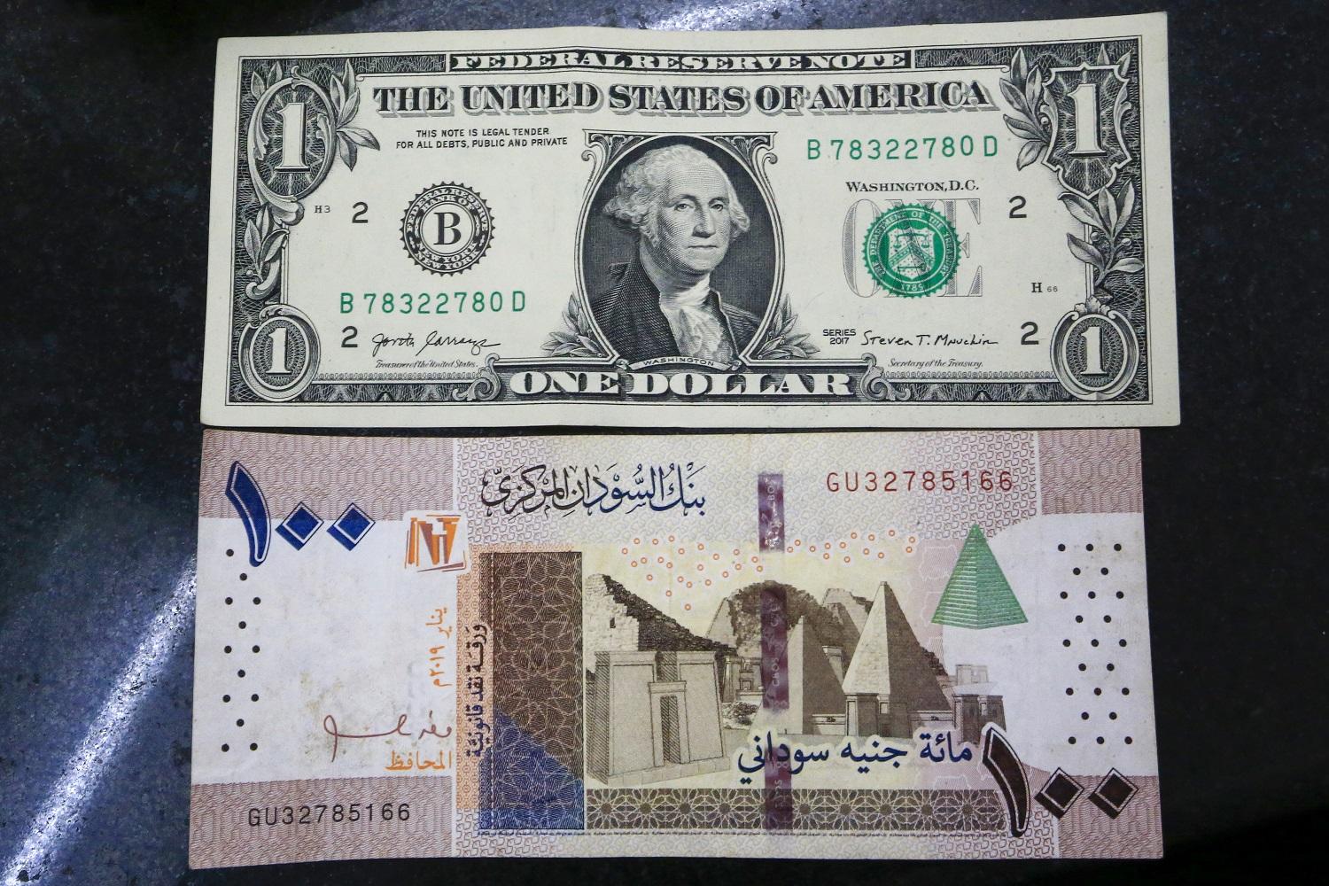 عملتا الدولار الأميركي والجنيه السوداني. (أ ف ب)