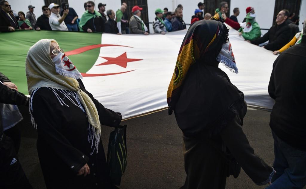 متظاهرون في مسيرة مع العلم الوطني الجزائري  خلال مظاهرة . 24 يناير 2020. رياض كرمي /أ ف ب 