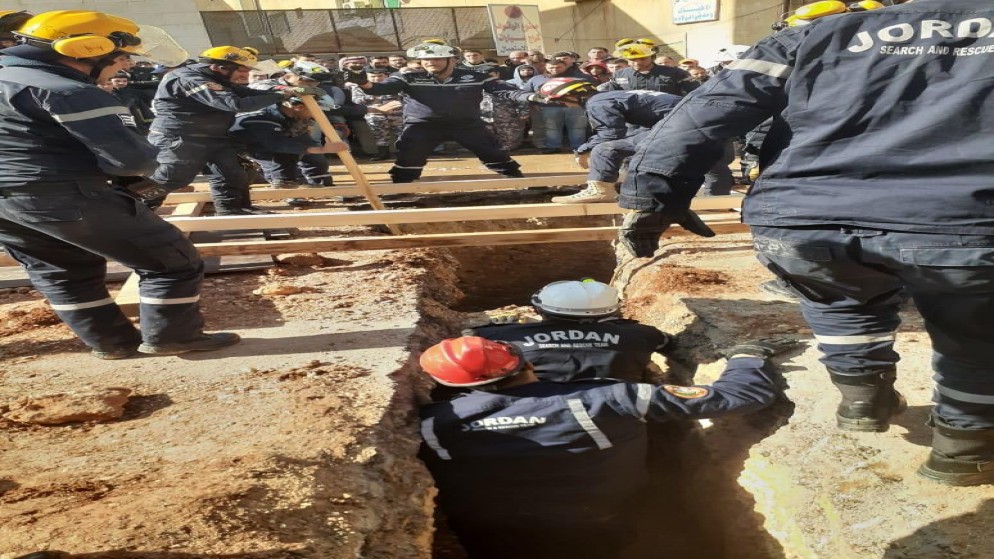 فرق الإنقاذ في مديرية دفاع مدني شرق عمّان، خلال تعاملهم مع حادث انهيار أتربة على عاملين في منطقة خريبة السوق. (الدفاع المدني)