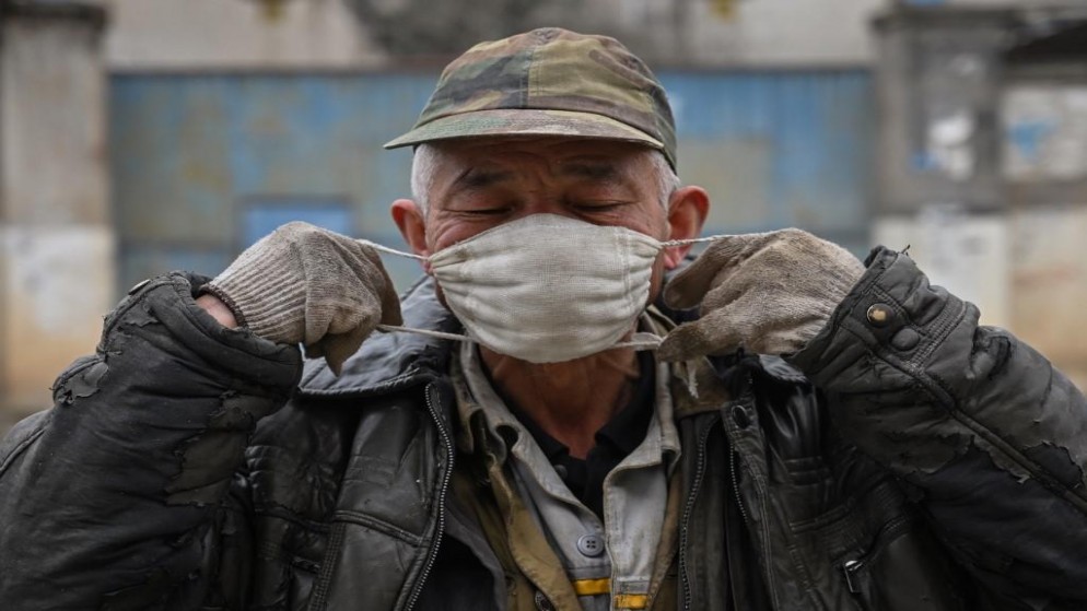 رجل يضع قناعًا واقيًا في أحد الأحياء على مشارف ووهان في مقاطعة هوبى وسط الصين، 27 كانون الثاني/يناير 2020. (أ ف ب)