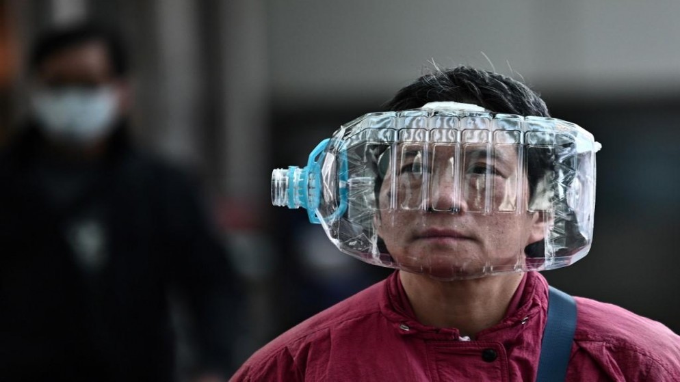 امرأة ترتدي قارورة بلاستيكية للوقاية من عدوى فيروس كورونا في هونغ كونغ. (أ ف ب)