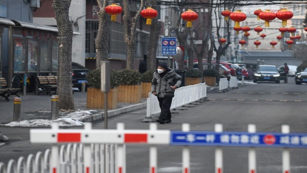 رجل يرتدي قناعًا واقيًا للوجه وهو يمشي داخل البوابة المغلقة لمجمع سكني في بكين .9 فبراير 2020. غريغ باكر / أ ف ب