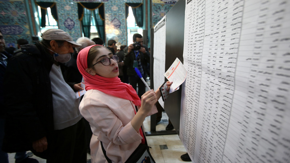 إيرانية تحاول اختيار مرشحها قبل الإدلاء بصوتها في الانتخابات البرلمانية في العاصمة طهران. (رويترز)