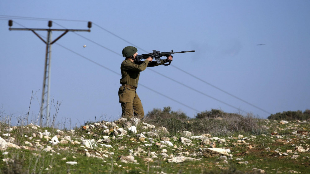عنصر في جيش الاحتلال الإسرائيلي يصوب سلاحه باتجاه فلسطينيين في الضفة الغربية المحتلة. (أ ف ب)