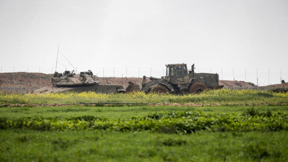 دبابة إسرائيلية من نوع ميركافا وجرافة قرب السياج الحدودي شرقي خان يونس في جنوب قطاع غزة.  23/02/2020. (سعيد الخطيب / أ ف ب)