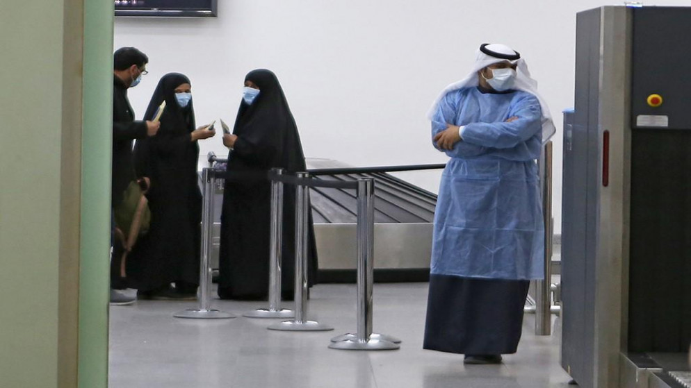 كويتيون عائدون من إيران ينتظرون في مطار الشيخ سعد في مدينة الكويت قبل نقلهم إلى المستشفى لفحصهم من فيروس كورونا. 22/02/2020. (ياسر الزيات / أ ف ب)