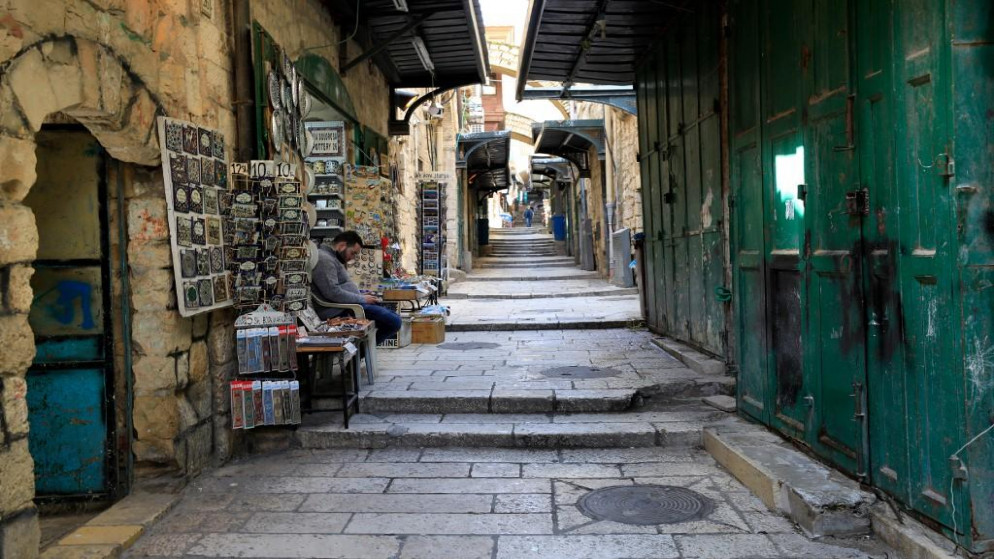 بائع متجر هدايا في انتظار الزبائن في البلدة القديمة في القدس المحتلة. 16/03/2020. (إيمانويل دوناند / أ ف ب)