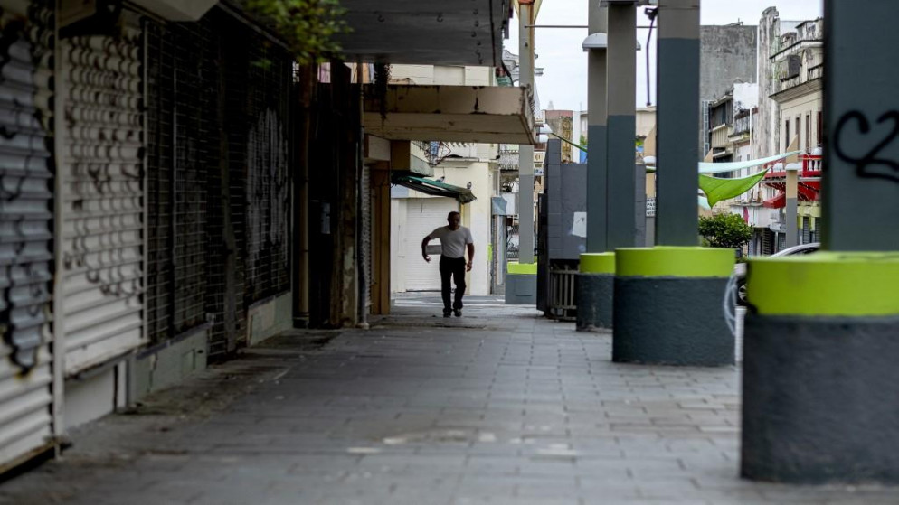 رجل يمشي في منطقة تجارية مغلقة في سان خوان في جزيرة بورتوريكو التابعة للولايات المتحدة. 25/03/2020. (ريكاردو أردونغو / أ ف ب)
