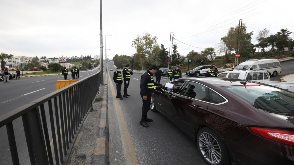 أفراد من الأمن العام عند نقطة غلق في منطقة الدوار الرابع في عمّان خلال فترة حظر تجول فرضته الحكومة للوقاية من فيروس كورونا. (أ ف ب)