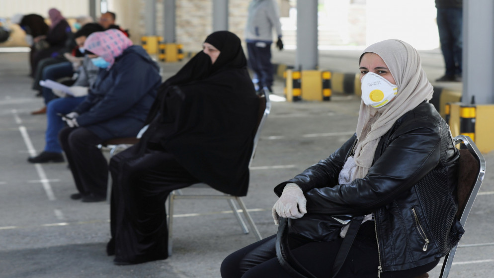 أشخاص يجلسون في طابور بانتظار دورهم في اختبارات يجريها أطباء متطوعين في عمّان وسط مخاوف من انتشار فيروس كورونا. 30/03/2020. (محمد حامد/ رويترز)