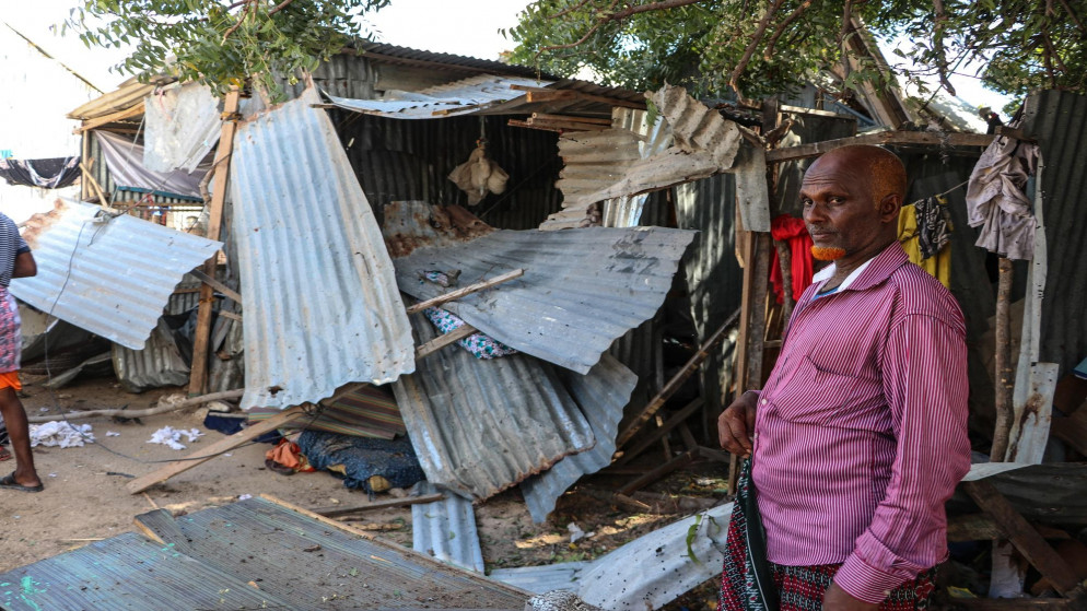 رجل يقف بجانب منزل دمر بعد هجوم ملسح في الصومال. (أ ف ب)