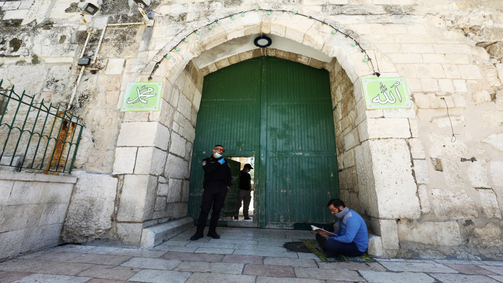 رجل يقرأ القرآن الكريم أمام مدخل الحرم الشريف في المسجد الأقصى في القدس المحتلة. 08/05/2020. (عمار عوض/ رويترز)
