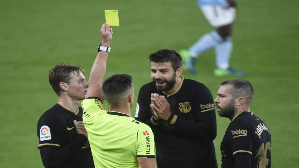 قدم الحكم الإسباني كارلوس ديل سيرو بطاقة صفراء لمدافع برشلونة الإسباني جيرارد بيكيه، 1 أكتوبر 2020. (أ ف ب)