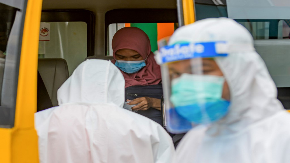 امرأة مصابة بفيروس كورونا تجلس في حافلة مدرسية في مركز صحي في جاكرتا قبل نقلها إلى المستشفى .1 أكتوبر 2020. (أ ف ب)