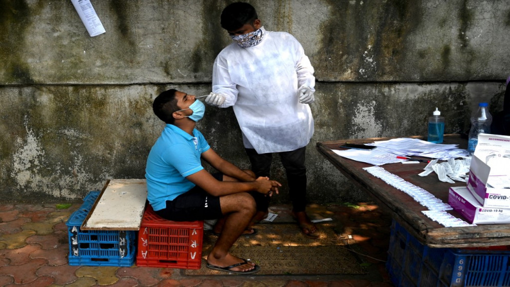 عامل صحي يجمع عينة خلال فحص طبي للفيروس، في مومباي، 3 أكتوبر 2020. (أ ف ب)