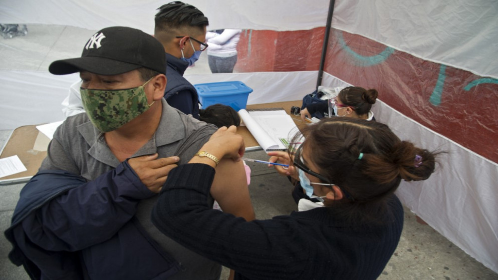 عامل صحي يعطي لقاح الإنفلونزا لرجل وسط جائحة فيروس كورونا COVID- 19، مكسيكو سيتي، 3 أكتوبر 2020. (أ ف ب)