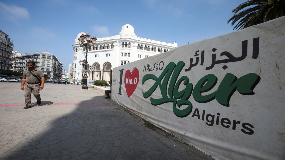 رجل يمر بجانب لافتة مكتوب عليها "أحب الجزائر" بالقرب من مكتب البريد المركزي في الجزائر العاصمة . الجزائر . 16 سبتمبر 2020. (رويترز)