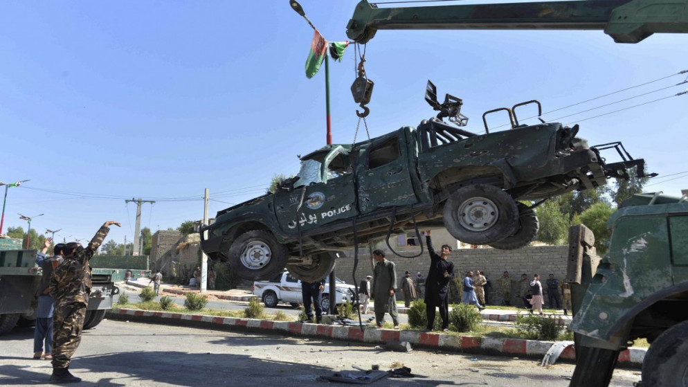 قوات أمن أفغانية تزيل سيارة شرطة متضررة في موقع انفجار سيارة مفخخة استهدفت موكب حاكم ولاية لغمان. 5 تشرين الأول/أكتوبر   2020 (أ ف ب)