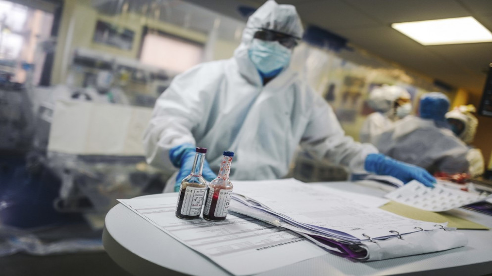 أحد أفراد الطاقم الطبي يقف بجانب عينات دم بعد رعاية مريض مصاب بفيروس كورونا المستجد في وحدة العناية المركزة بمستشفى في باريس. 09/04/2020. (لوكاس باريوليه / أ ف ب)