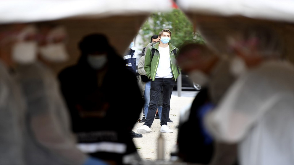رجل ينتظر خارج خيمة ويقوم رجال بجمع عينات فحص فيروس كورونا المستجد في فرنسا. 2 تشرين الأول/أكتوبر 2020  (أ ف ب)
