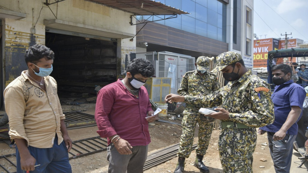 أصدر حراس بلدية، غرامة مالية لرجل بسبب عدم ارتداء كمامة، وسط جائحة فيروس كورونا، في بنغالور، 8 أكتوبر 2020. (أ ف ب)