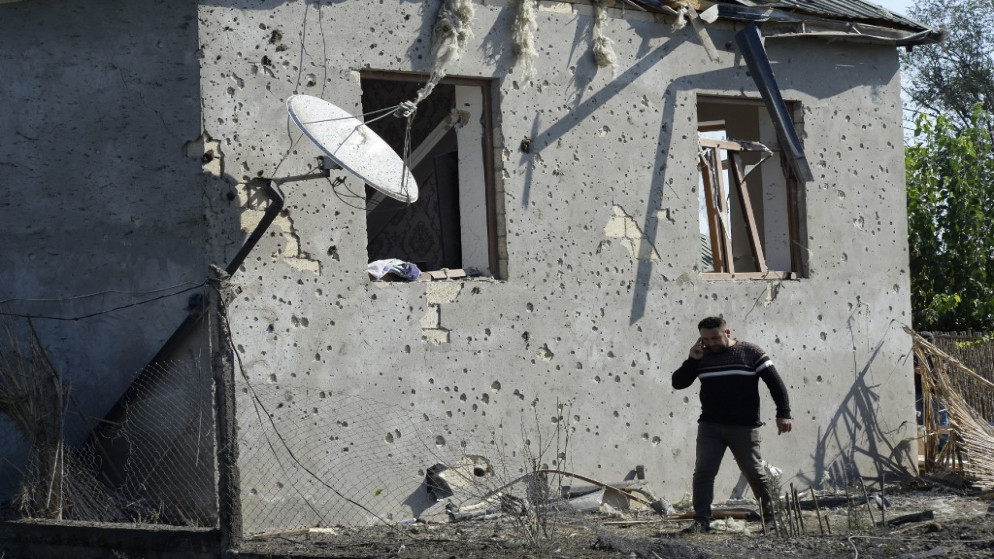 رجل يسير أمام منزل قيل إنه أصيب بأضرار جراء القصف أثناء القتال الدائر بين أرمينيا وأذربيجان حول منطقة ناغورني كاراباخ المتنازع عليها. 09/10/2020. (توفيق باباييف / أ ف ب)