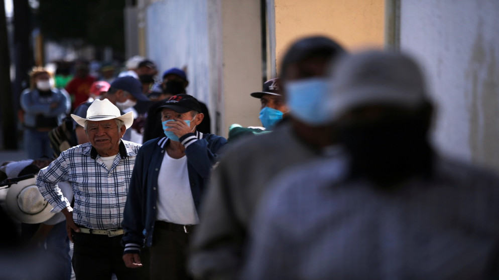 أشخاص يصطفون للحصول على طعام مجاني في مطبخ حساء مجتمعي أثناء تفشي الفيروس، في سيوداد خواريز، المكسيك، 15  تشرين الأول/ أكتوبر 2020. (رويترز)