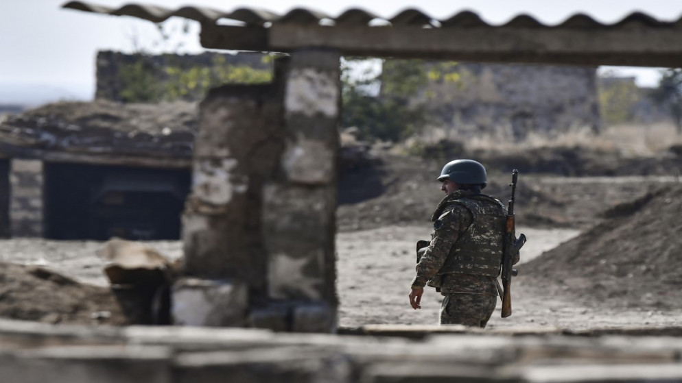 جندي أرميني يسير قرب خط المواجهة حيث يتصاعد القصف بين أرمينيا وأذربيجان. (أ ف ب)